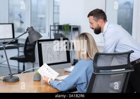Technicians making digital engineering drawing on computer at desk in office Stock Photo
