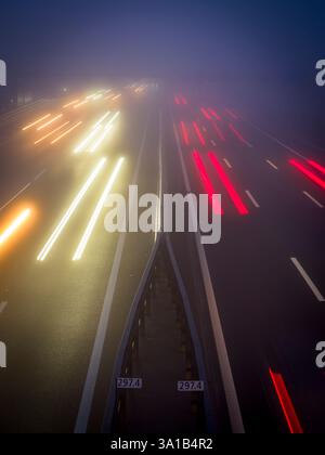 Light trails in the fog on the highway Stock Photo