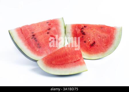 Juicy watermelon slices on a white surface, showing off vibrant red flesh and green skin. Stock Photo