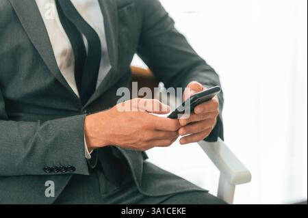 Close up view of businessman that is sitting and using smartphone. Stock Photo