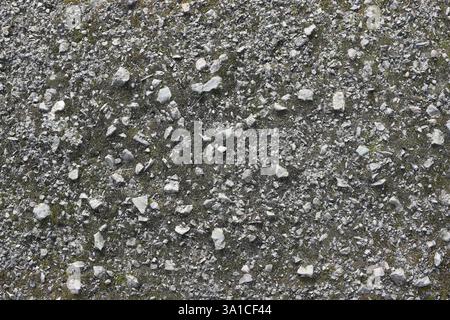 A gray and white background with a lot of rocks and pebbles. The rocks are scattered all over the background, creating a rough and uneven texture. Sce Stock Photo
