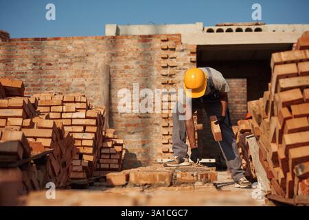 Focused on work. Handsome Indian man is on the construction site. Stock Photo
