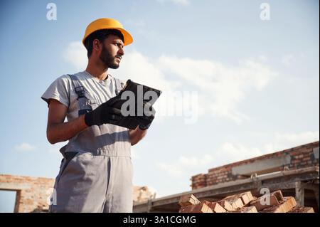 Manager with digital tablet. Handsome Indian man is on the construction site. Stock Photo