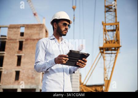 Manager in sunglasses. Handsome Indian man is on the construction site. Stock Photo
