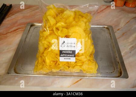 A bag of potato chips with the word patatas on it. The chips are yellow and are in a plastic bag Stock Photo