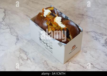 A sandwich is sitting in a white box with a black border. The sandwich is filled with vegetables and cheese Stock Photo