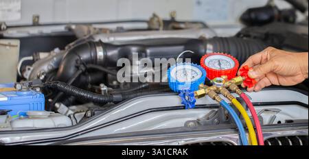 Car air conditioner check service, leak detection, fill refrigerant.Device and meter liquid cooling in the car by specialist technicians. Stock Photo