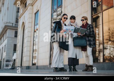 Three businesswomen collaborating outdoors while reviewing documents and discussing ideas Stock Photo