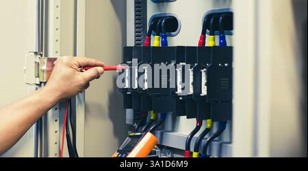 Electrical engineers test electrical installations and electrical wiring by measuring them with a multimeter. Stock Photo
