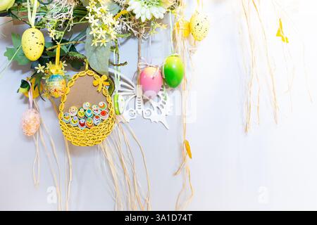 Spring and Easter hanging wall decorations with colorful Easter eggs, flowers and butterfly, origami decorations, home decor, white background. Stock Photo