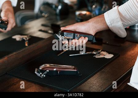 Close up view of barber hand that is holding hair clipper. Stock Photo