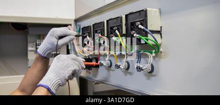 Technicians use multimeter to test or diagnose electrical control devices. Stock Photo