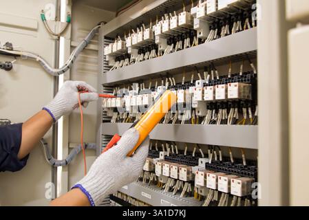 Technicians use multimeter to test or diagnose electrical control devices. Stock Photo