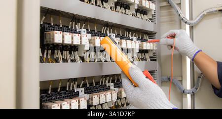 Technicians use multimeter to test or diagnose electrical control devices. Stock Photo