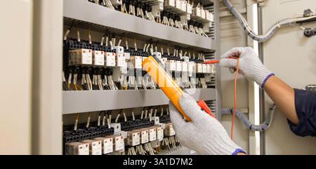 Technicians use multimeter to test or diagnose electrical control devices. Stock Photo