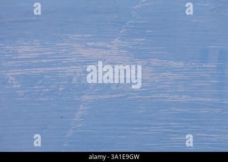 Close-up of blue paint brushed over steel, with visible brush strokes adding texture on top of the grounding layer. Detailed and artistic Stock Photo