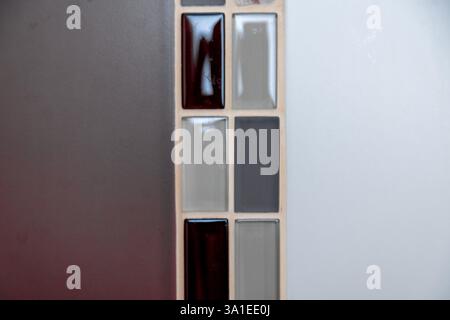 A tile wall with a floral design and a white background. The design is made up of small squares of different colors Stock Photo