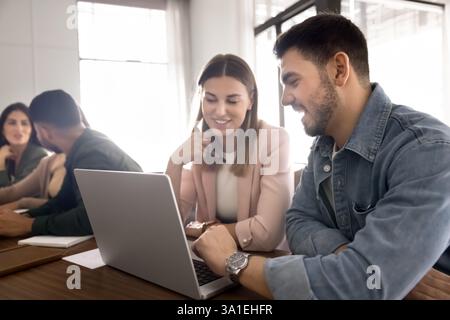 Collaborative workflow session between two multiethnic colleagues using laptop Stock Photo