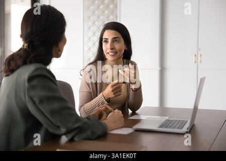 Colleagues discussing joint task, engaged in teamwork Stock Photo