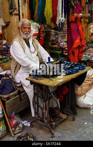 Jaisalmer, Rajasthan, India - February 12 2025: Man Sewing on an Old Manual Singer Sewing Machine Stock Photo