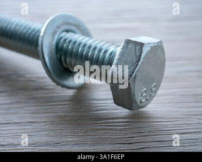 Bolt with washer on wooden surface table close up Stock Photo