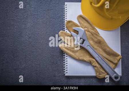Notebook hard hat adjustable wrench protective gloves construction concept Stock Photo