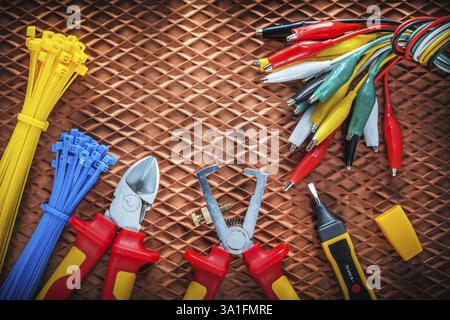 Insulation wire strippers cutter tying cables electric tester crocodile plugs on dielectric mat Stock Photo