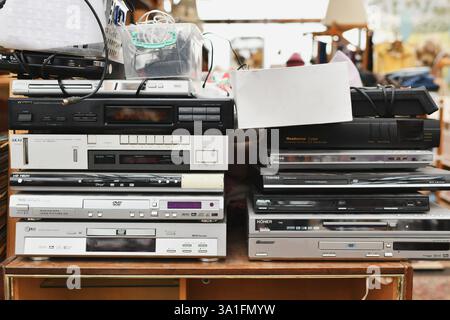 VERONA, ITALY - MARCH 04, 2023: Vintage Retro audio video devices on a flea market. Stack of many DVD CD players Stock Photo