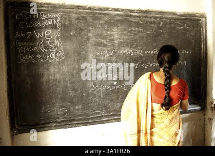 School teacher writing on blackboard, Ngo Patang, Sambalpur, Orissa, India MR#717A Stock Photo