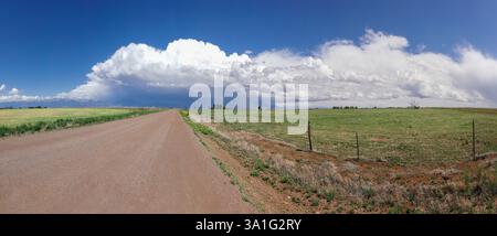 Panorama of a country road in rural Colorado with storm clouds in the distance, Colorado, USA Stock Photo