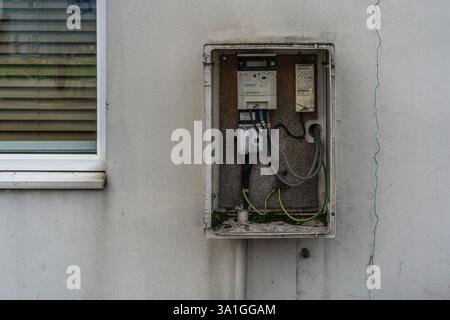 Open electricity meter box fitted on an external wall facade on a house in the UK, England, UK Stock Photo