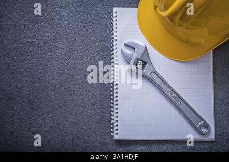 Notebook hard hat adjustable wrench construction concept Stock Photo