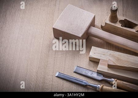 Lump hammer shaving plane metal flat chisels and wooden stud on brown board construction concept Stock Photo
