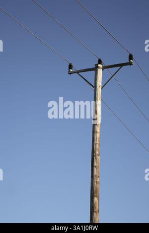Wooden electric poles with electric wires against blue sky Stock Photo ...