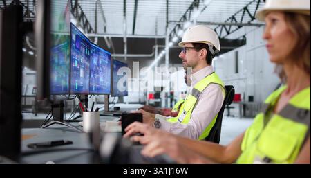 Multiracial team using Scada automation software in modern semiconductor factory. Stock Photo