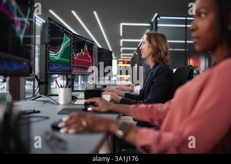 Diverse team of stock brokers in office analyzing market trends. Stock Photo