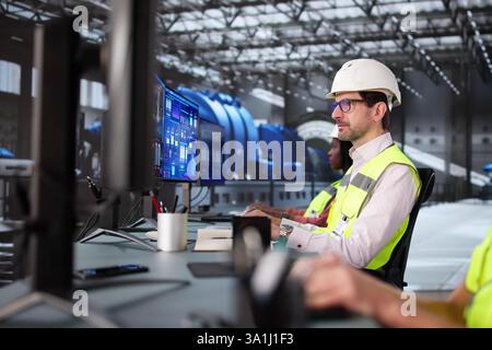 Skilled engineers monitoring gas pipes control with advanced SCADA software. Stock Photo