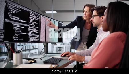 Busy professionals work together on diverse software coding projects in office. Stock Photo