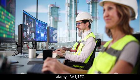 Mature Black Man and Woman Using SCADA to Monitor Factory Stock Photo