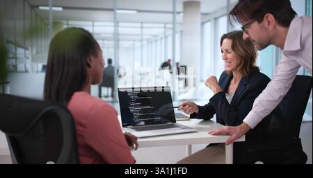 Busy Programmer Juggling Code in High-Tech Meeting Room. Talented Engineer Leading Diverse Business Team in Late-Night Coding Session. Stock Photo
