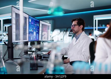 Doctor and engineer analyze pharmaceutical data in science lab Stock Photo