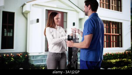 Happy man delivering dry cleaning service package to business recipient. Stock Photo
