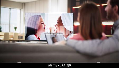 Man watching internet streaming from connected tablet to television at home, consultant, marketer, technology specialist, media integration. Stock Photo