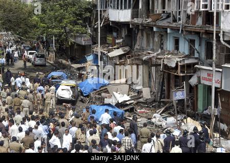 Policemen inspecting site of bomb blast also large number of people gathered to look at the site at Zaveri Bazaar in busy Kalbadevi area, Bombay Mumba Stock Photo