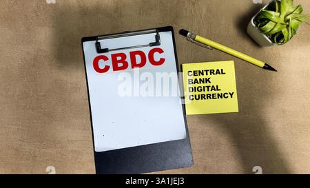 Concept of CBDC - Central Bank Digital Currency write on sticky notes isolated on Wooden Table. Stock Photo