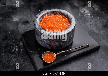 Exquisite salmon roe, vibrant and rich, ideal for adding a touch of elegance to your culinary creations. black background. top view. Stock Photo