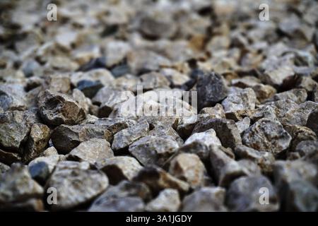 Close-up light beige and white small stones, gravel rugged background Texture. irregularly shaped, light colored stones Stock Photo