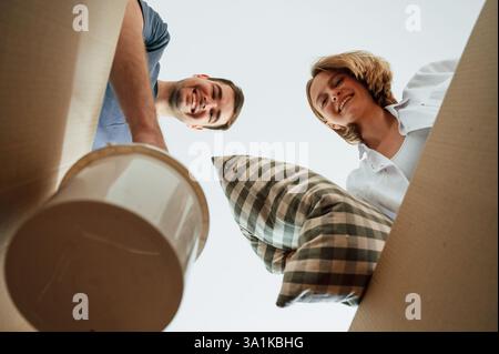 View from the inside of a box. Young couple moving to new home. Stock Photo