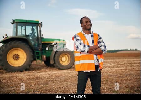 Standing with arms crossed. Beautiful African American man is in the agricultural field. Stock Photo