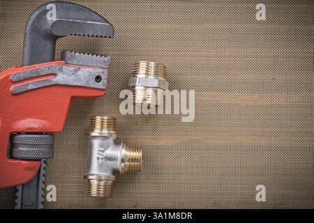 Plumbers wrench brass connector fittings on cleaning mesh filter grid ...